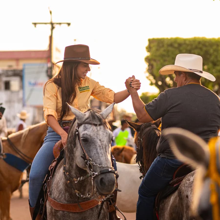 Débora Menezes a cavalo cumprimentando um produtor rural no interior
